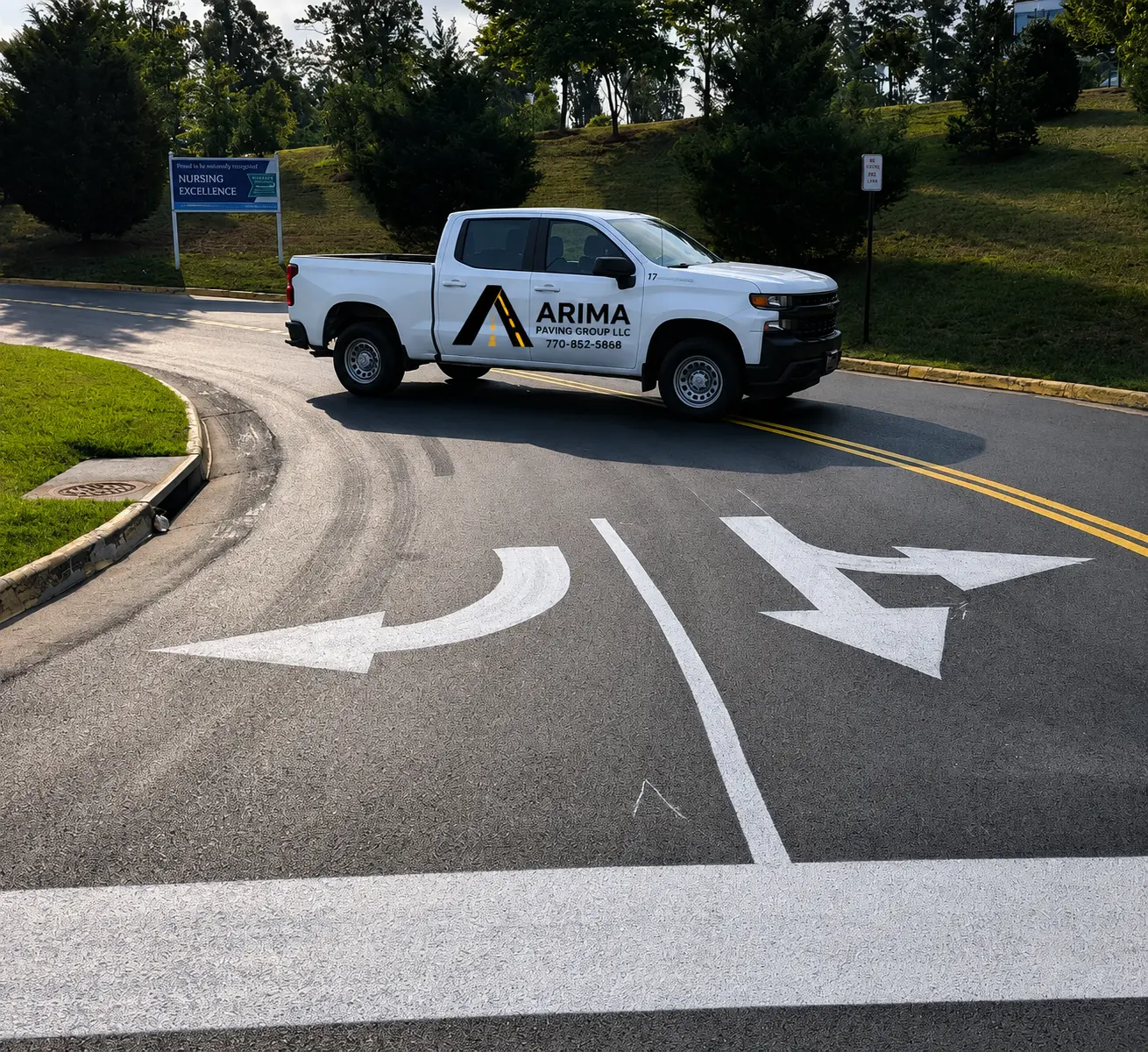 ARIMA Paving Group truck beside freshly striped directional arrows